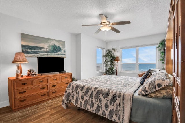 bedroom with wood-type flooring, a textured ceiling, and ceiling fan