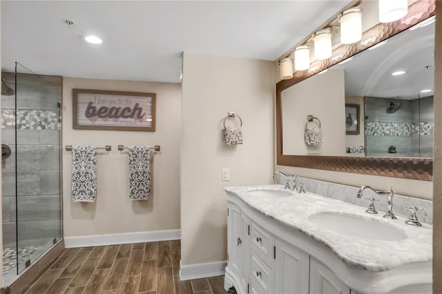 bathroom featuring a tile shower, vanity, and wood-type flooring