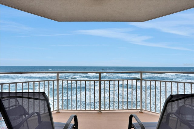 balcony featuring a water view and a view of the beach