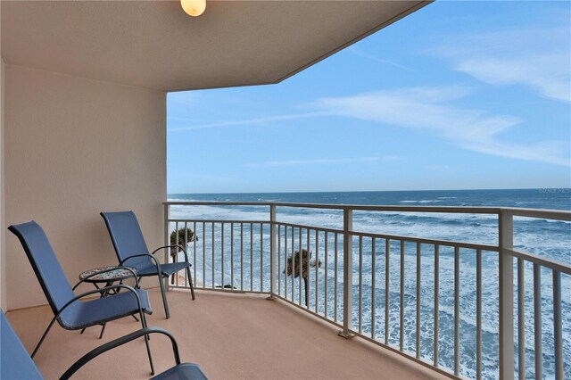 balcony with a water view and a beach view