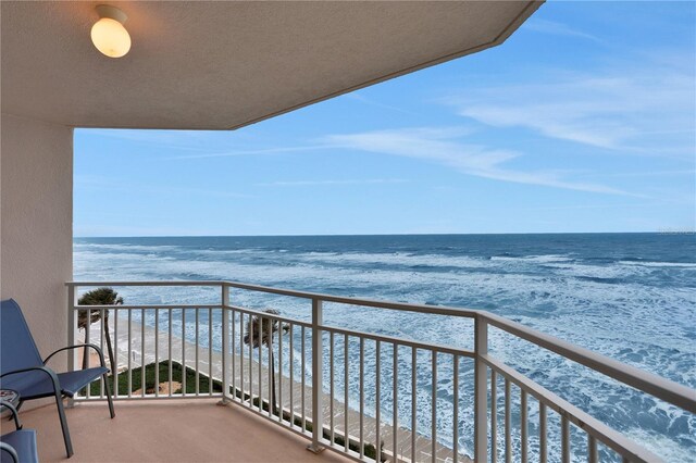 balcony featuring a water view and a view of the beach