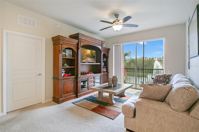 carpeted living room with ceiling fan