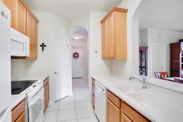 kitchen featuring light brown cabinets, light tile patterned floors, white appliances, and sink