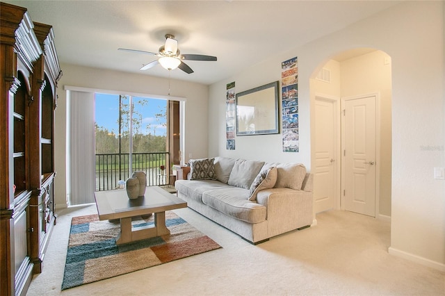 carpeted living room with ceiling fan