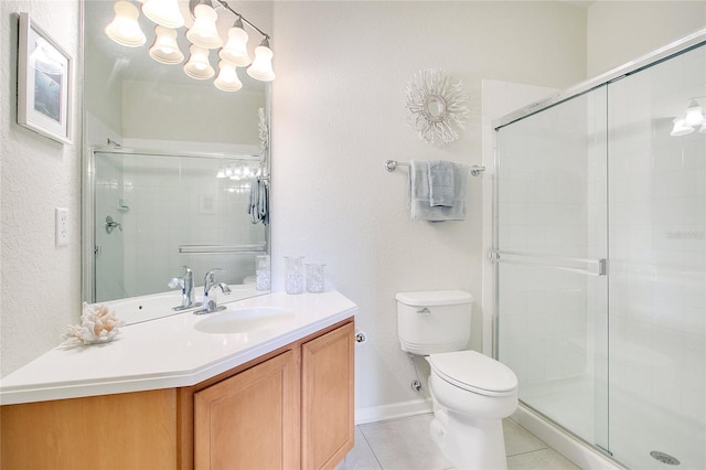 bathroom with tile patterned floors, vanity, toilet, and a shower with door