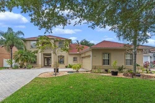 mediterranean / spanish house featuring a garage and a front lawn