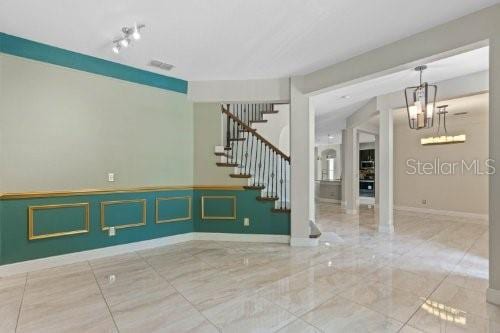 unfurnished room featuring a notable chandelier