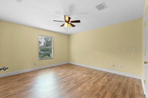 empty room with ceiling fan and wood-type flooring