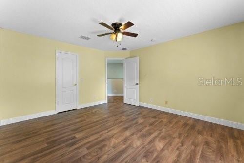 unfurnished bedroom featuring dark hardwood / wood-style floors and ceiling fan