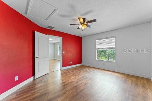 empty room with hardwood / wood-style flooring, ceiling fan, and a textured ceiling