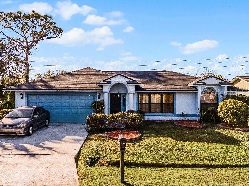 single story home with a front yard and a garage