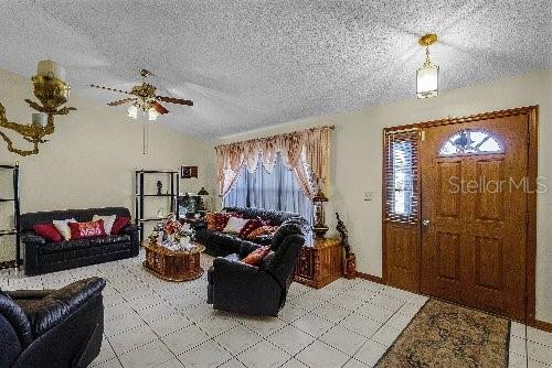 living room with a textured ceiling and ceiling fan