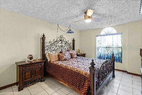 bedroom featuring ceiling fan and a textured ceiling