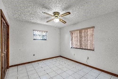 empty room featuring ceiling fan and a textured ceiling