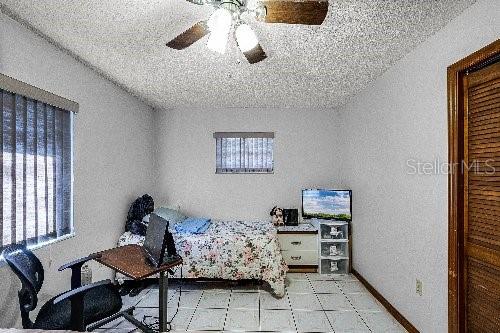 bedroom featuring a textured ceiling and ceiling fan