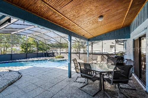 view of swimming pool with glass enclosure and a patio area