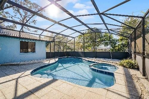 view of swimming pool featuring a lanai, an in ground hot tub, and a patio