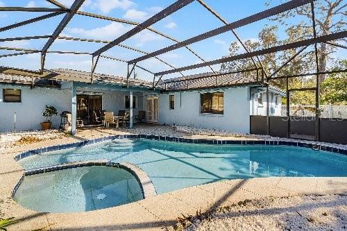 view of swimming pool with a lanai, an in ground hot tub, and a patio