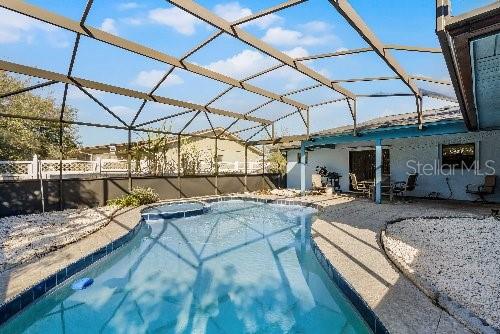 view of swimming pool featuring a patio area and a lanai