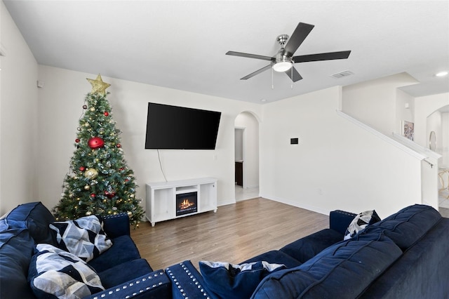 living room with wood-type flooring and ceiling fan