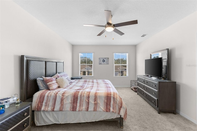 carpeted bedroom with a textured ceiling and ceiling fan