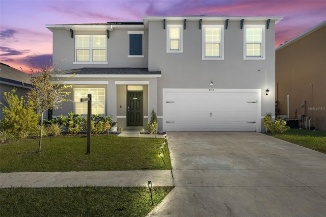 view of front facade with a yard and a garage