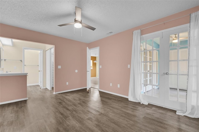 spare room featuring a textured ceiling, ceiling fan, dark hardwood / wood-style flooring, and french doors