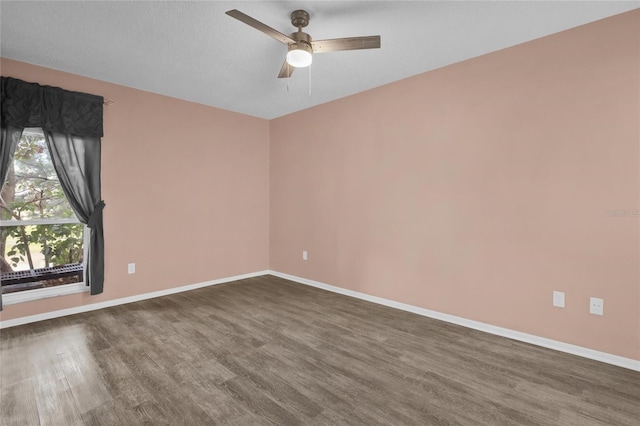 empty room with ceiling fan, dark hardwood / wood-style flooring, and a textured ceiling