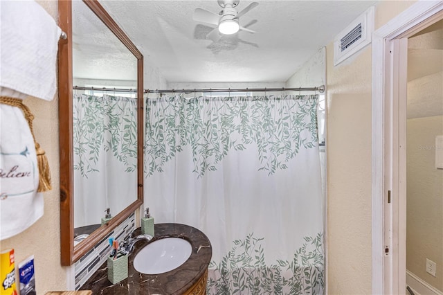 bathroom featuring vanity, a textured ceiling, ceiling fan, and curtained shower