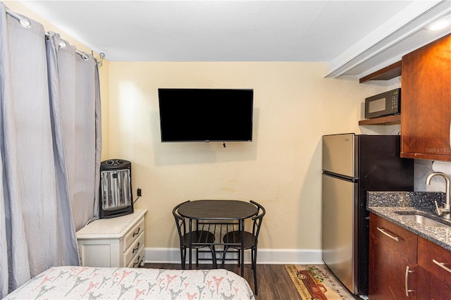 bedroom featuring stainless steel fridge, dark wood-type flooring, and sink