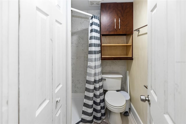 bathroom featuring tasteful backsplash and toilet