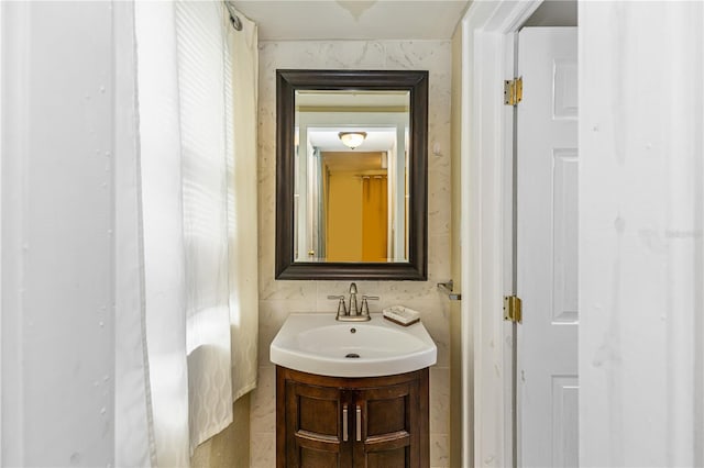 bathroom with vanity and tile walls