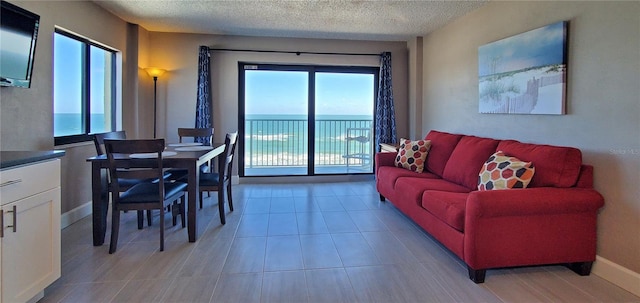 living room featuring a textured ceiling and a water view