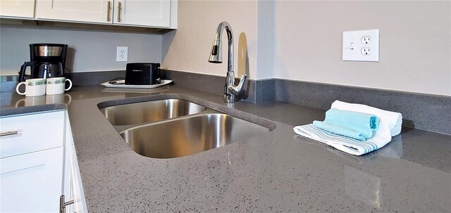 kitchen featuring white cabinets and sink