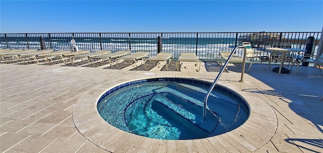 view of pool featuring a community hot tub, a patio, and a water view