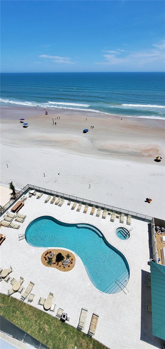 view of pool featuring a view of the beach and a water view