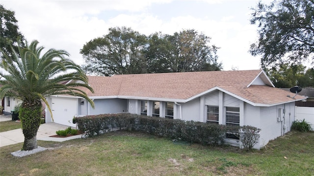 single story home with a garage and a front lawn