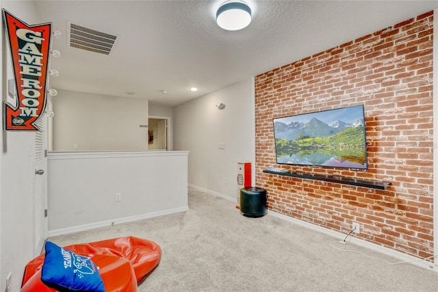 living area featuring carpet flooring, a textured ceiling, and brick wall