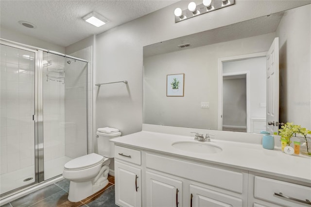 bathroom with tile patterned flooring, vanity, a textured ceiling, and walk in shower