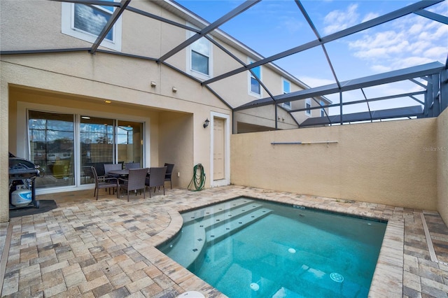 view of swimming pool featuring a grill, a patio, and glass enclosure