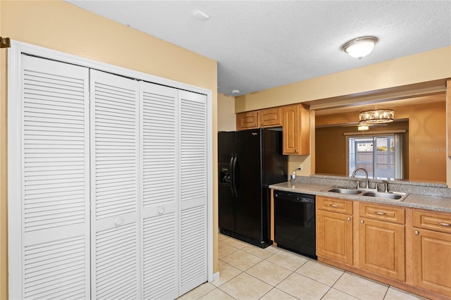 kitchen with a chandelier, sink, light tile patterned floors, and black appliances