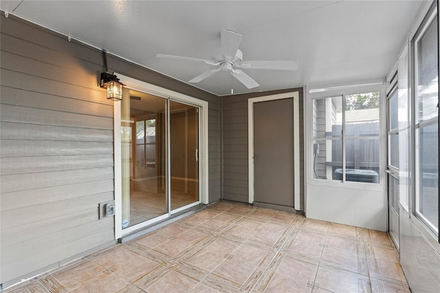 unfurnished sunroom with ceiling fan