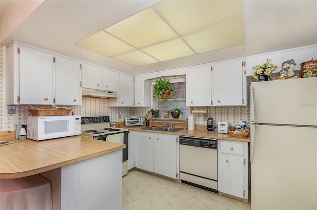 kitchen featuring kitchen peninsula, white appliances, white cabinetry, and sink