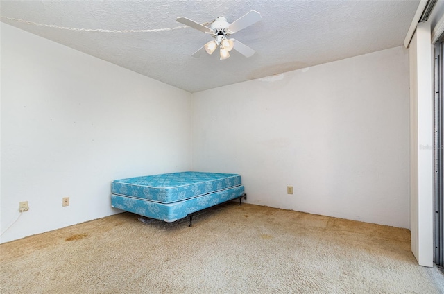 bedroom featuring carpet flooring, a textured ceiling, and ceiling fan