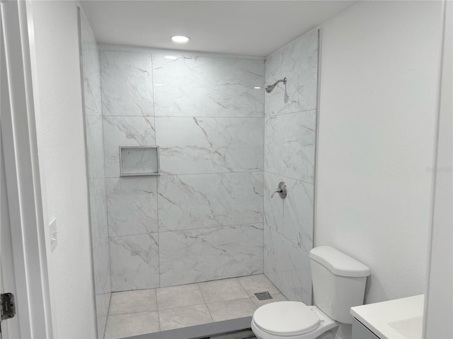 bathroom featuring vanity, toilet, and tiled shower