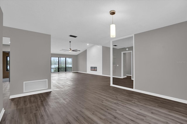 unfurnished living room with a fireplace, ceiling fan, dark hardwood / wood-style flooring, and vaulted ceiling