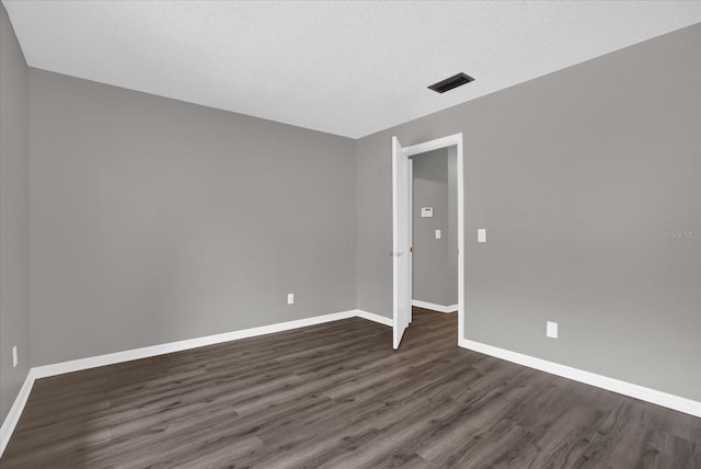 unfurnished room featuring a textured ceiling and dark wood-type flooring