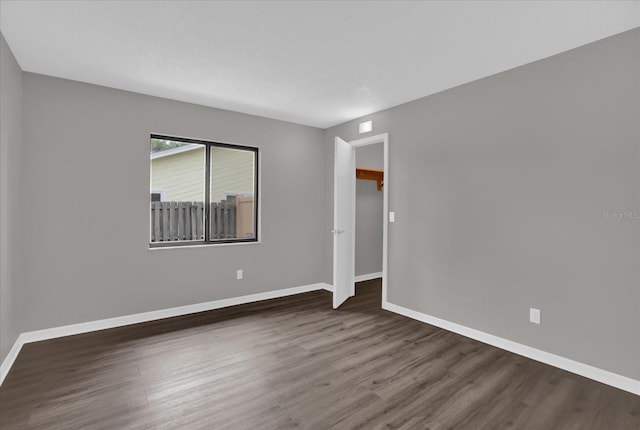 empty room with dark hardwood / wood-style flooring