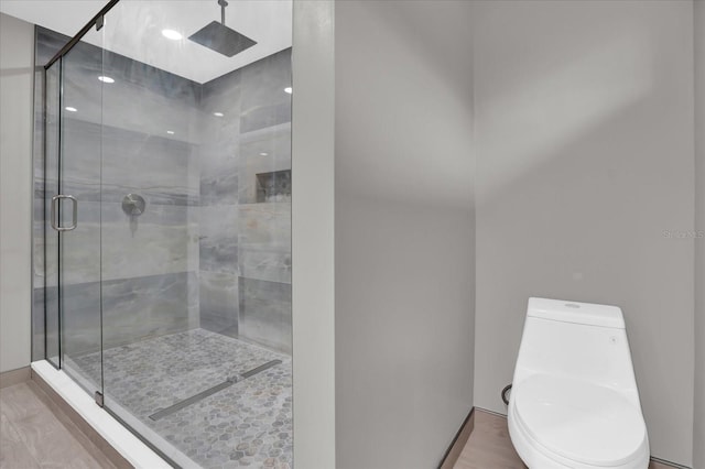 bathroom featuring hardwood / wood-style floors, an enclosed shower, and toilet