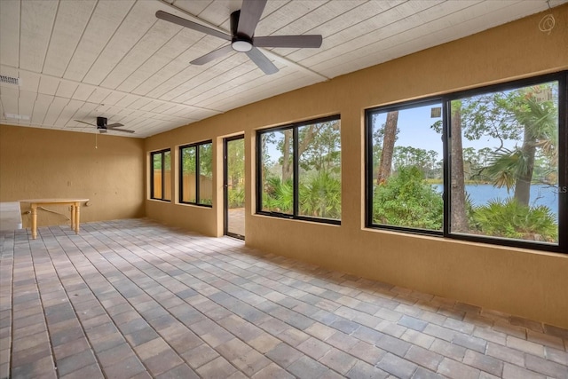 unfurnished sunroom with a water view, plenty of natural light, and ceiling fan